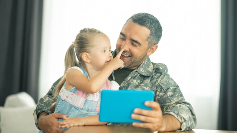 Dad in military uniform with daughter.